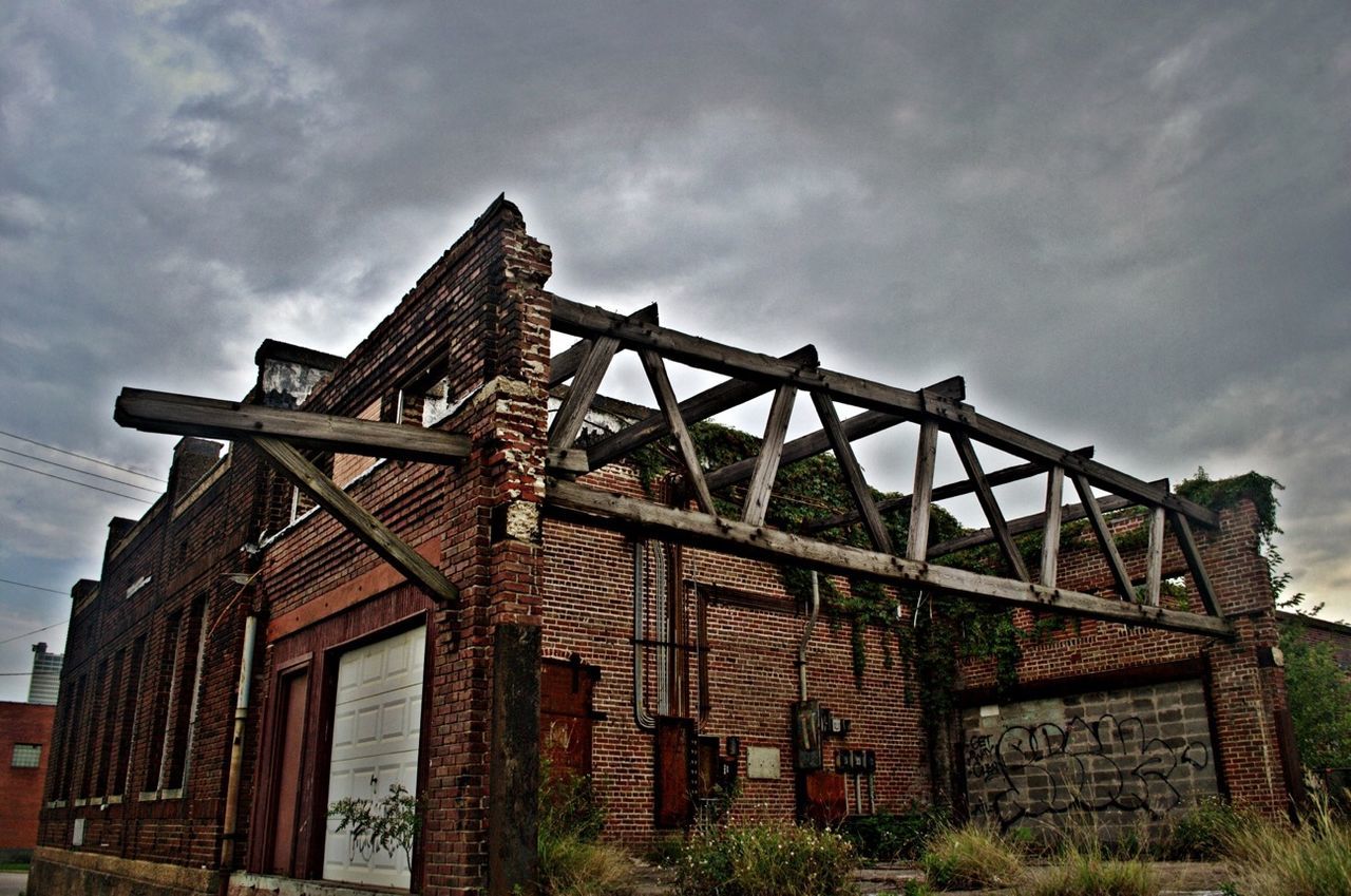 LOW ANGLE VIEW OF BUILT STRUCTURES AGAINST CLOUDY SKY