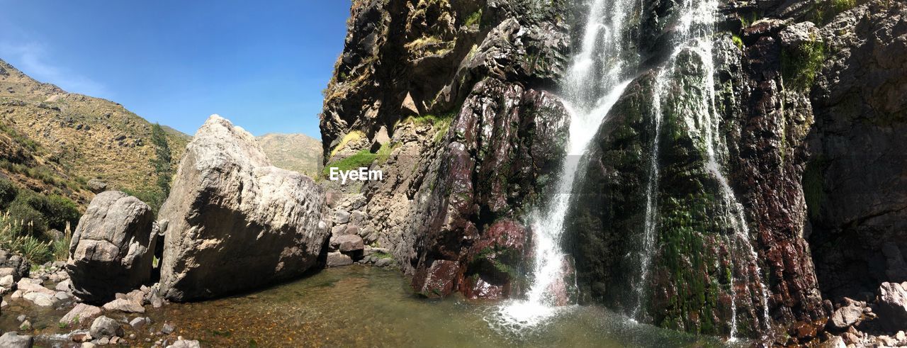 PANORAMIC VIEW OF WATERFALL AGAINST SKY