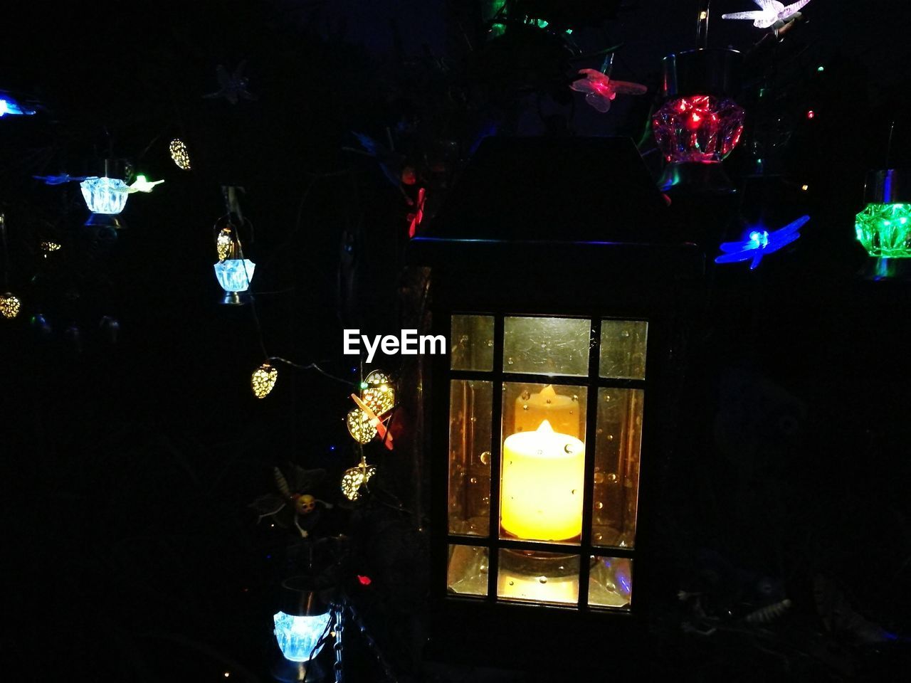 LOW ANGLE VIEW OF ILLUMINATED LANTERNS HANGING ON WALL