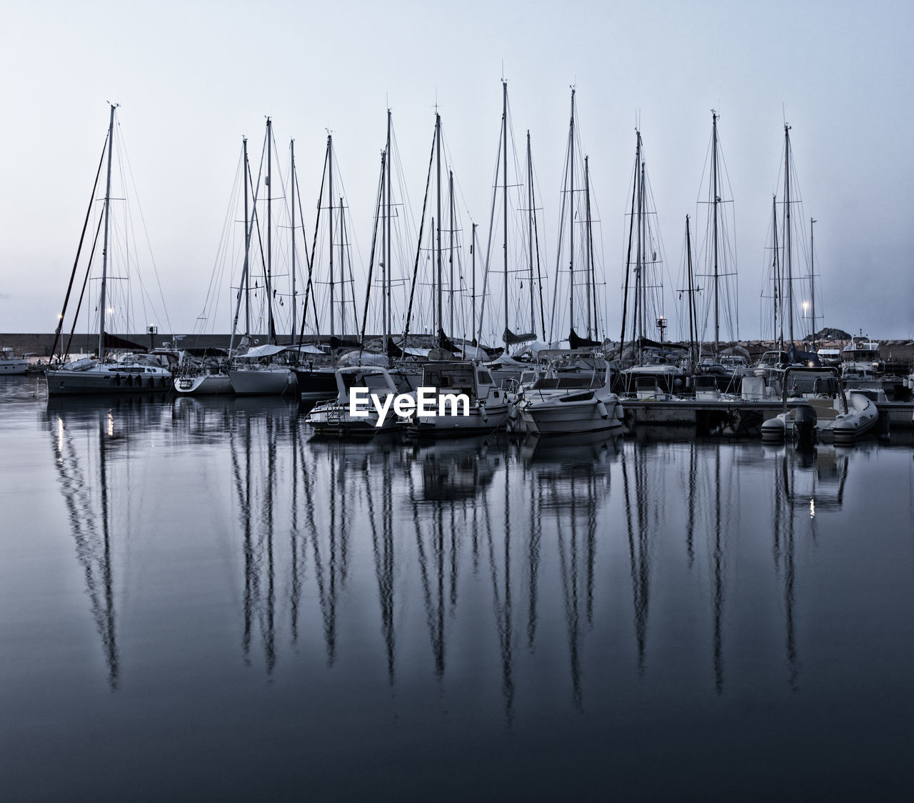 SAILBOATS MOORED AT HARBOR