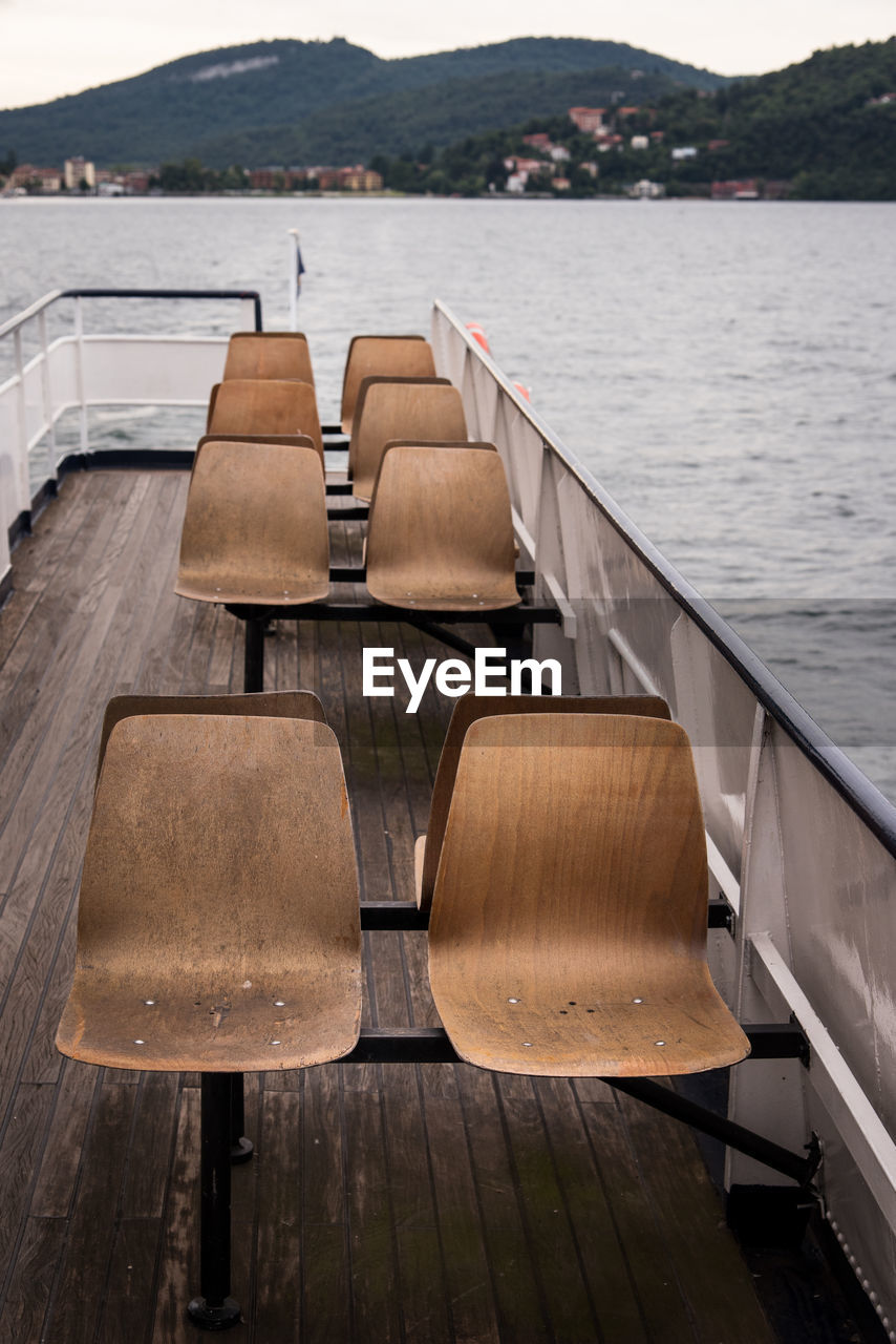 EMPTY CHAIR ON PIER BY LAKE