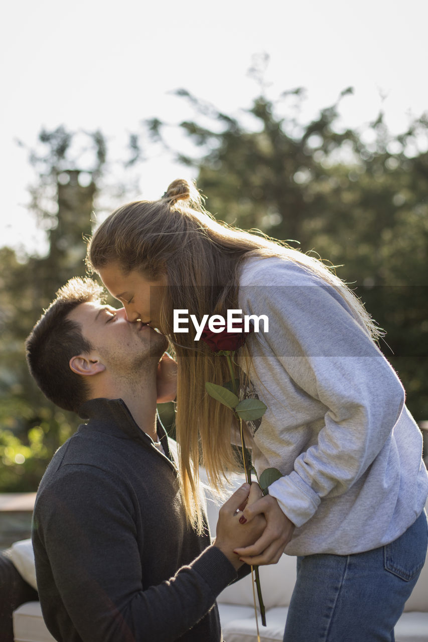 Side view of couple kissing outdoors