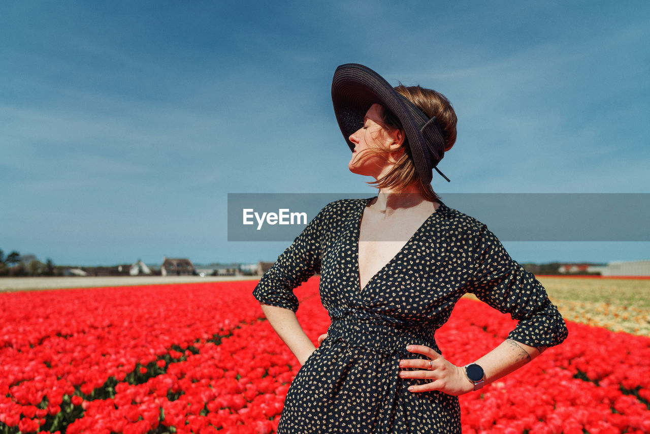 Full length of woman standing on field against sky