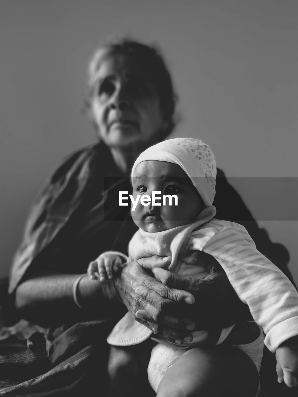 Low angle view of grandmother holding granddaughter while sitting at home