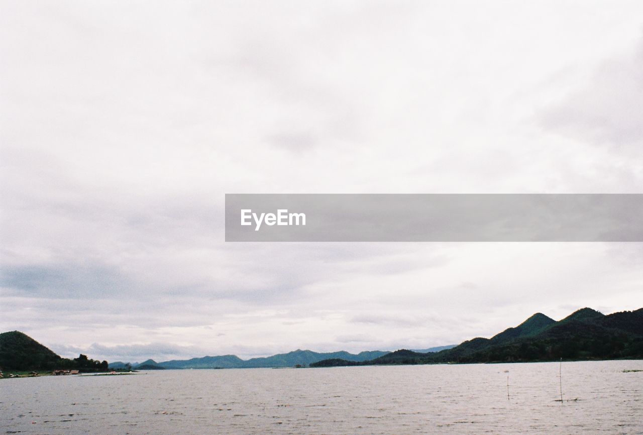 SCENIC VIEW OF SEA AGAINST MOUNTAINS