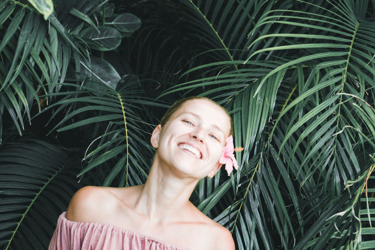 Portrait of smiling woman by plants