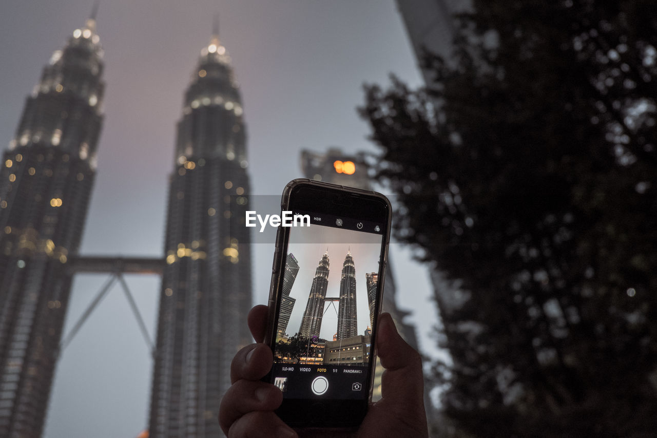 LOW ANGLE VIEW OF PERSON USING MOBILE PHONE