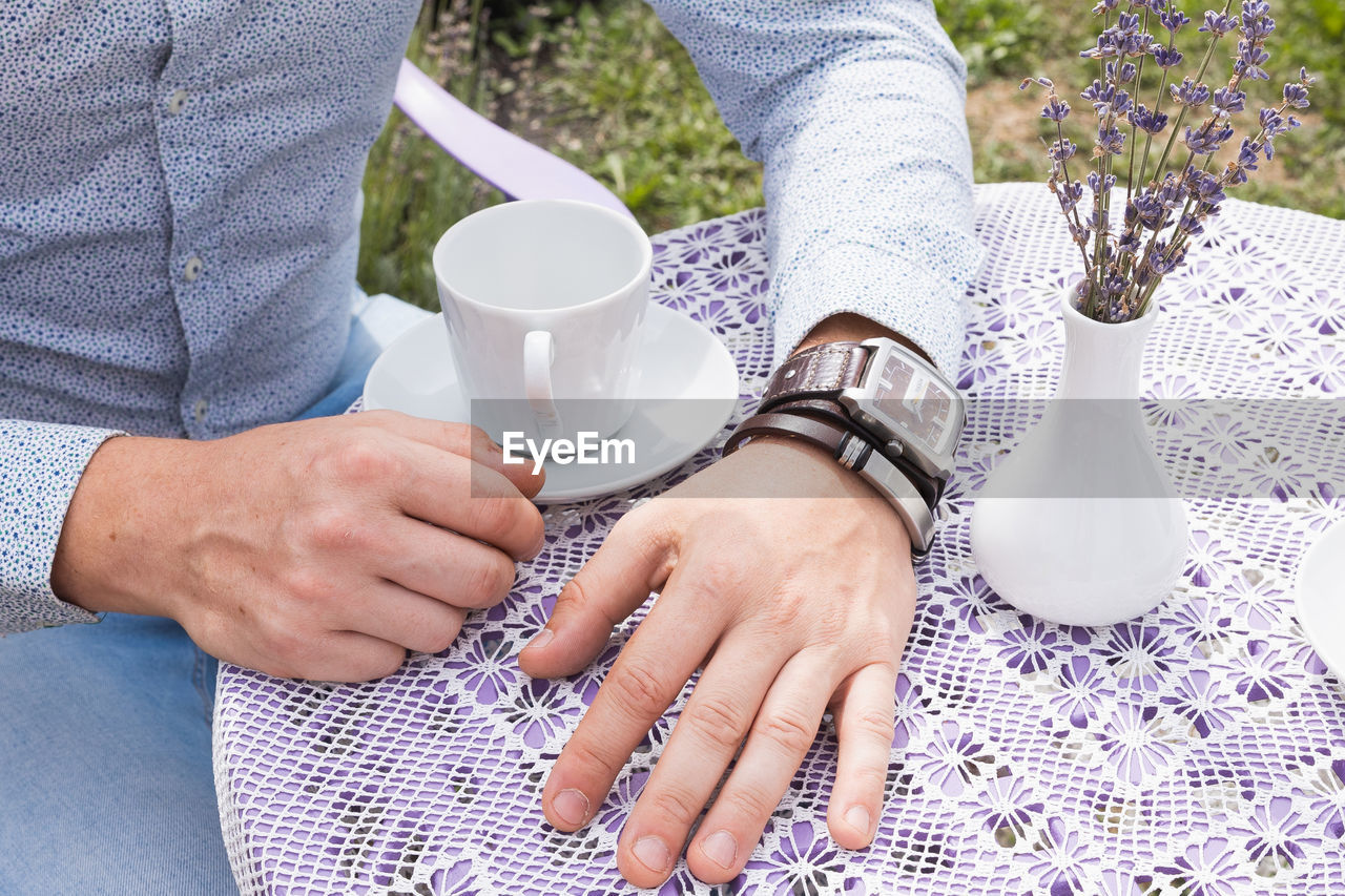 adult, hand, women, drink, cup, food and drink, mug, midsection, lifestyles, pattern, casual clothing, togetherness, leisure activity, two people, clothing, coffee, coffee cup, refreshment, men, high angle view, day, sitting, holding, finger, relaxation, nature, table, person, outdoors, bonding, spring, young adult, female, textile, close-up, plant, friendship, human leg