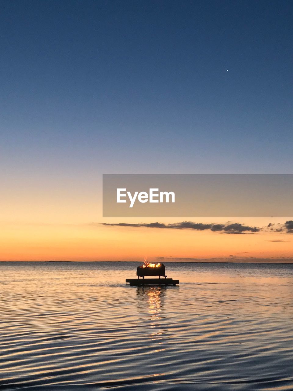 Boat sailing on sea against sky during sunset