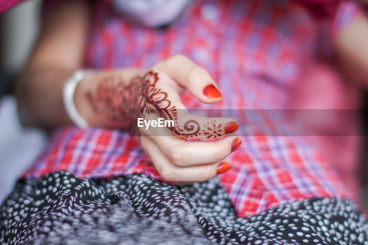 Midsection of woman with henna tattoo