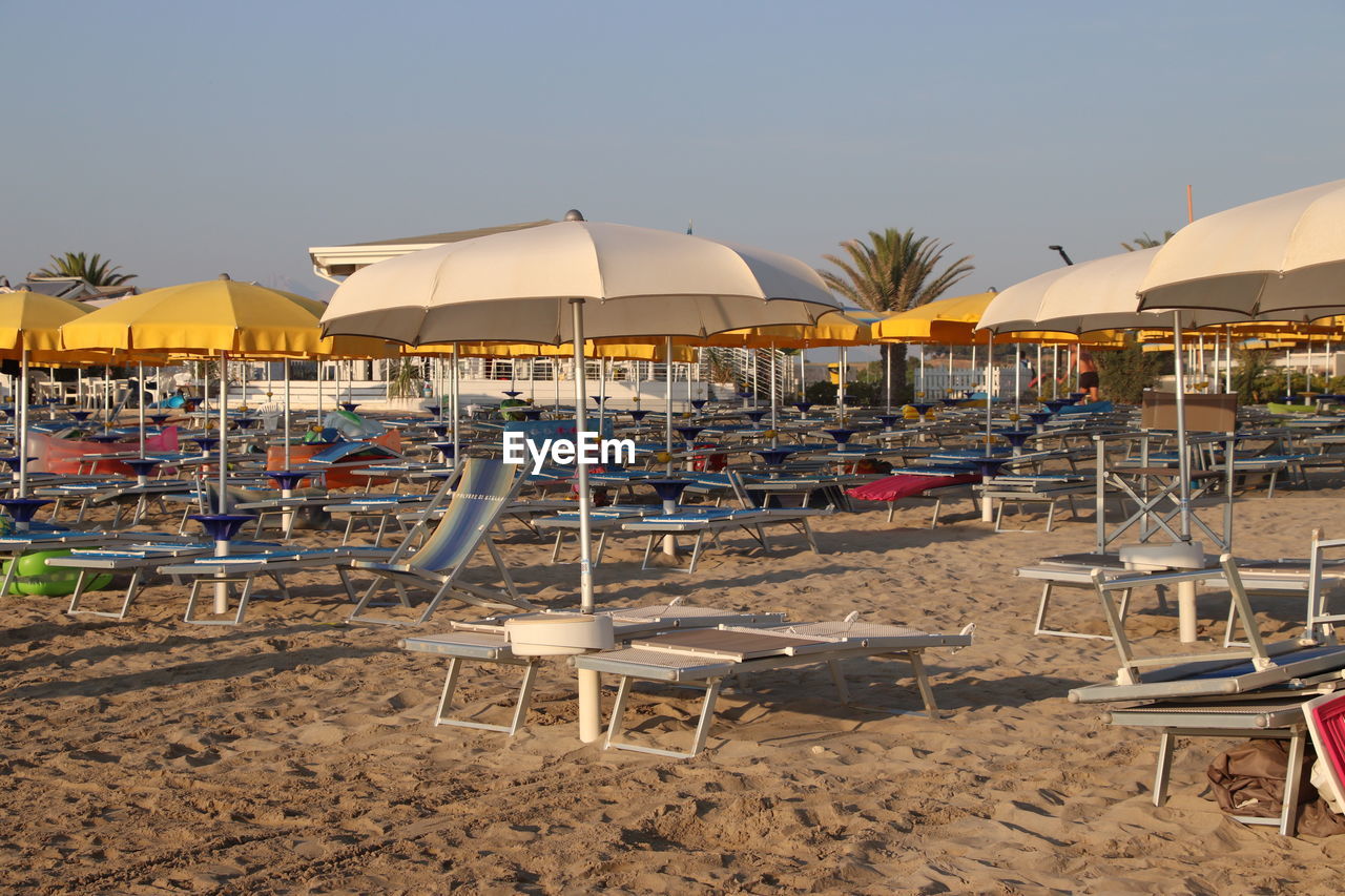 LOUNGE CHAIRS AND TABLES ON BEACH
