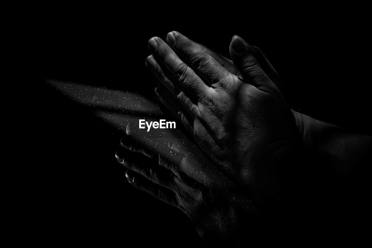 Close-up of hands against black background