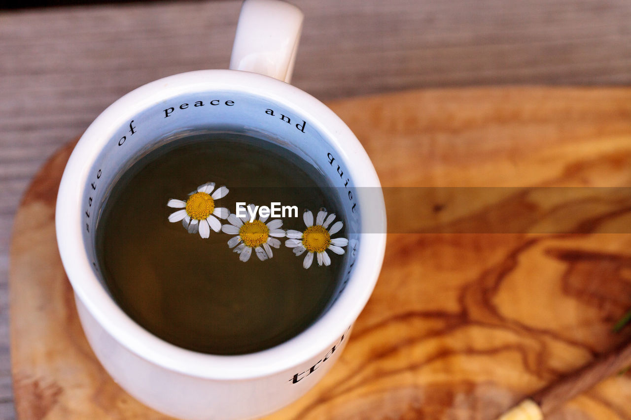 Close-up of white daisies in herbal tea on table