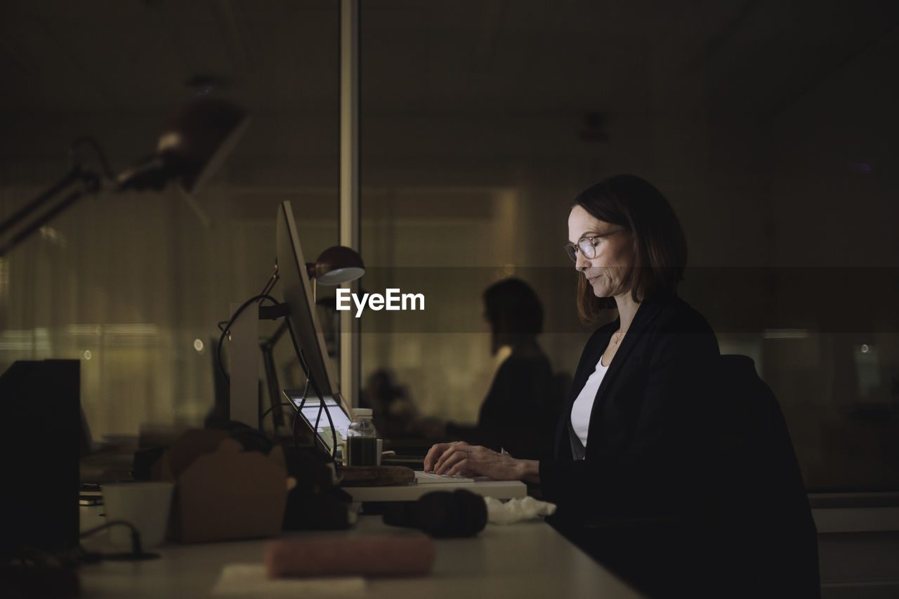 Businesswoman concentrating while working on laptop in office at night