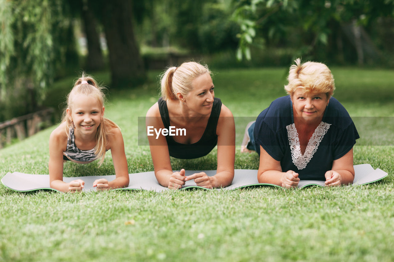 Multi generational family exercising plank on grass
