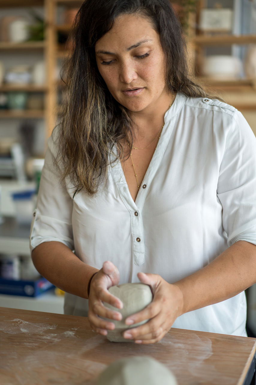Woman kneading clay to make pottery