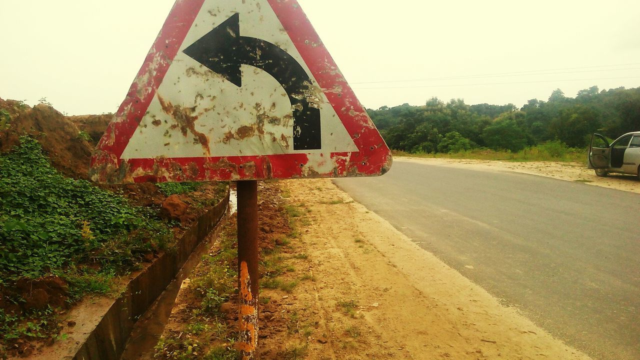 Old rusty directional sign at roadside