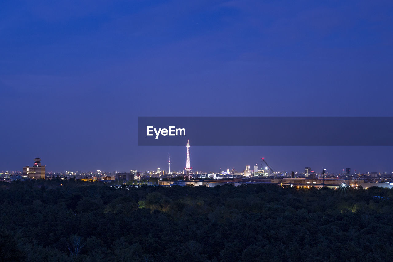 ILLUMINATED CITY AGAINST SKY AT NIGHT