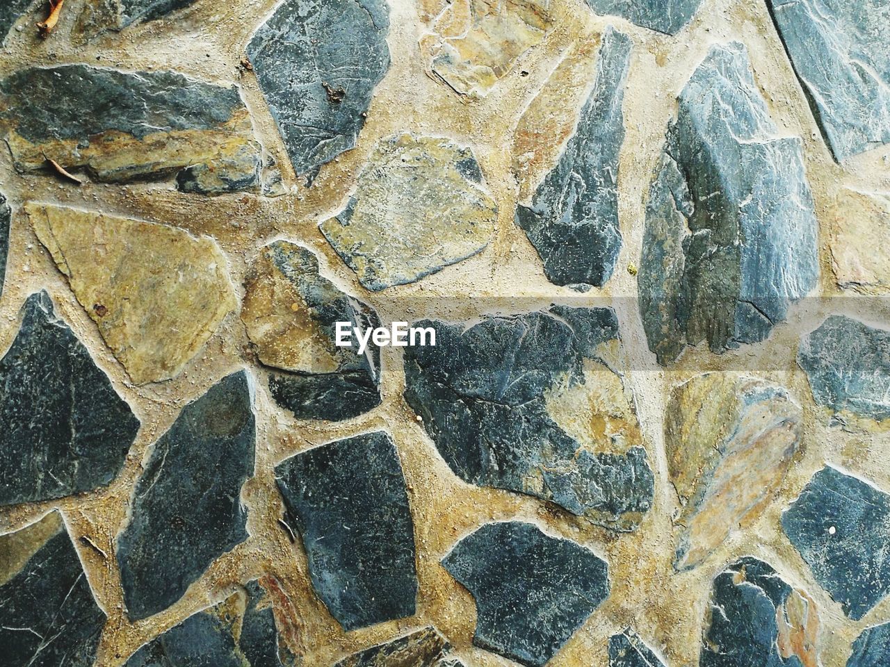 FULL FRAME SHOT OF STONE WALL WITH TILED FLOOR