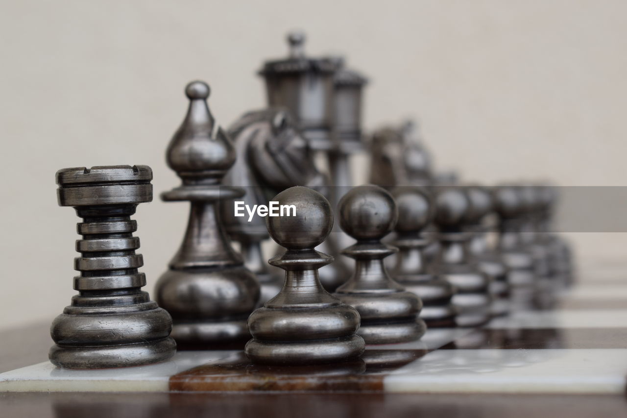 FULL FRAME SHOT OF CHESS PIECES ON WOODEN
