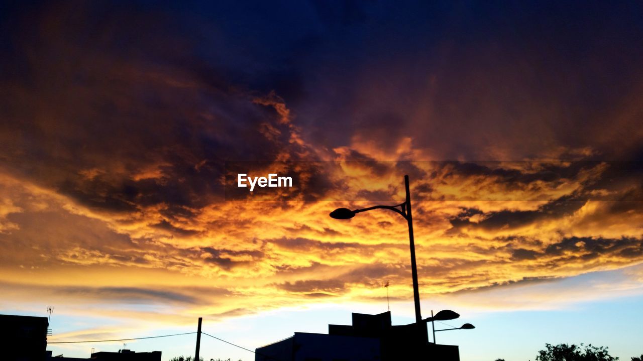 LOW ANGLE VIEW OF STREET LIGHT AGAINST SKY AT SUNSET