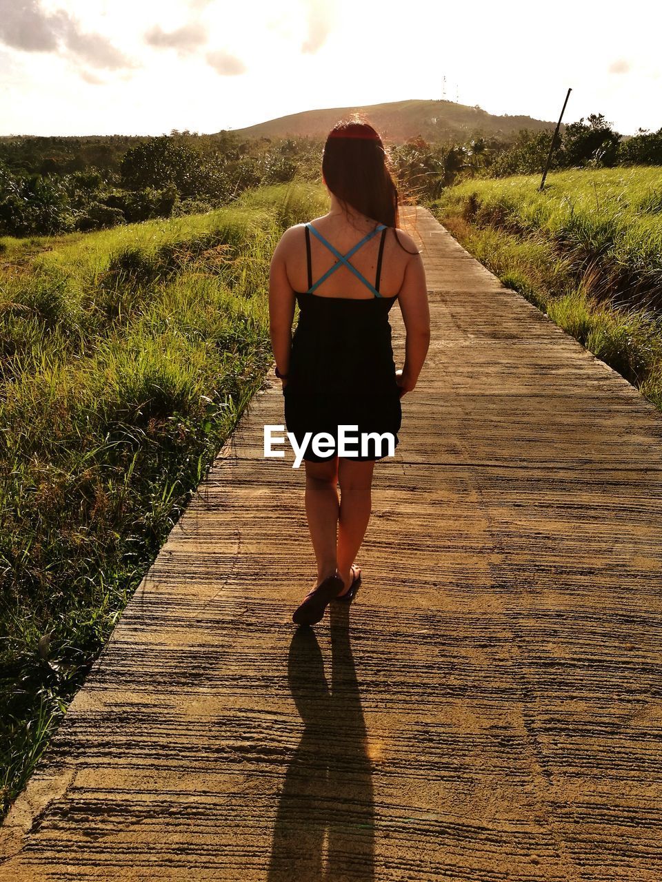 Rear view of woman walking on boardwalk