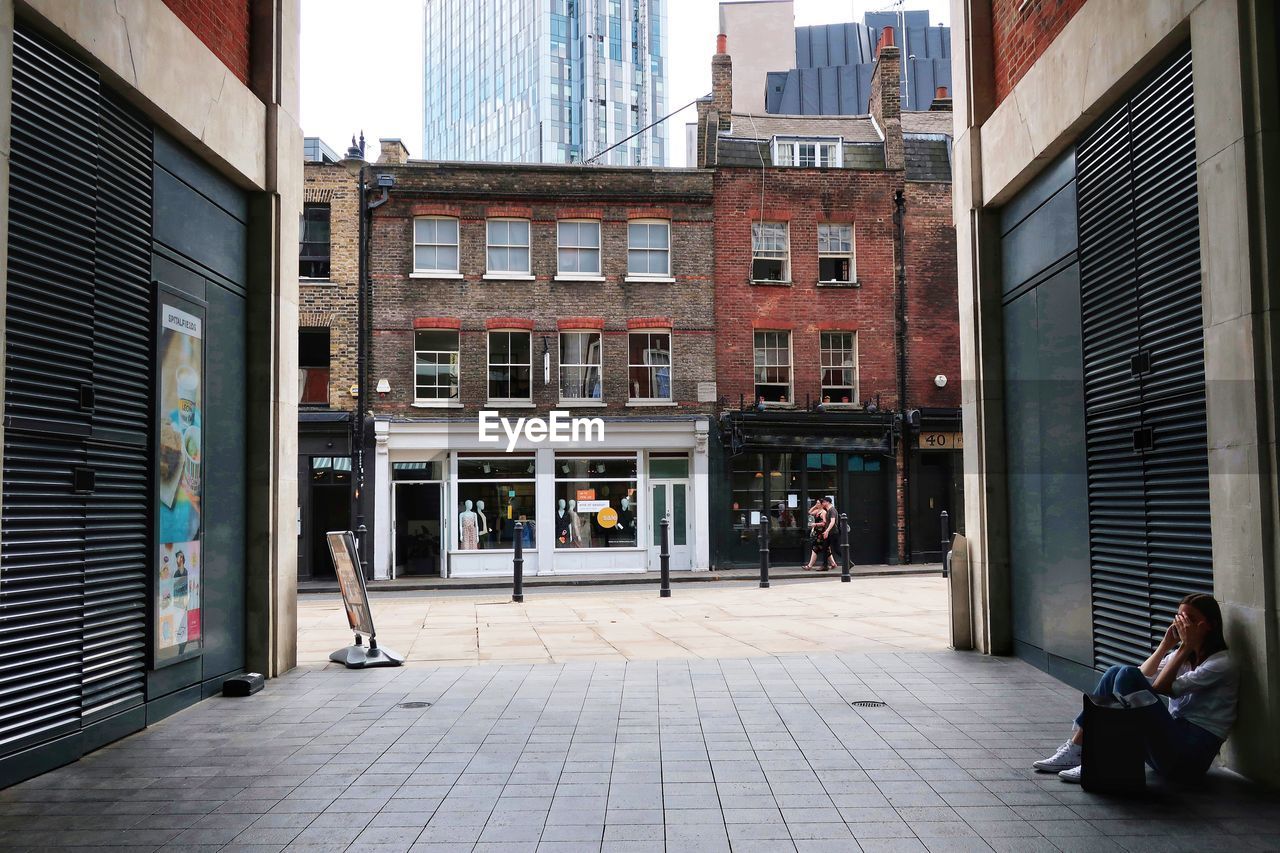 PEOPLE ON FOOTPATH BY BUILDINGS