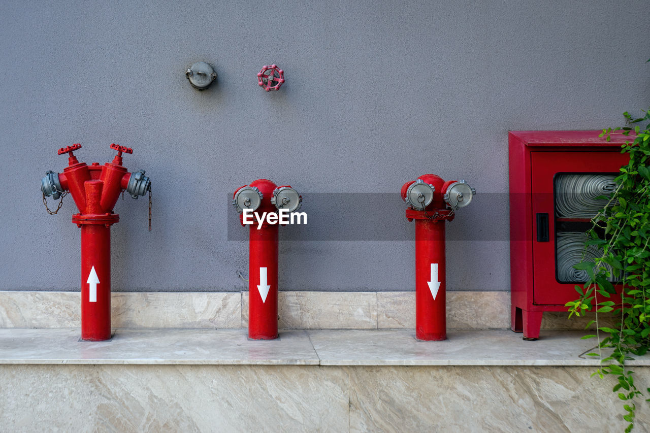 RED FIRE HYDRANT BY WALL