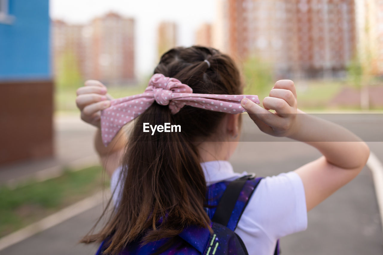 Back to school. girl in school uniform with parent go to school with backpack behind their backs. 