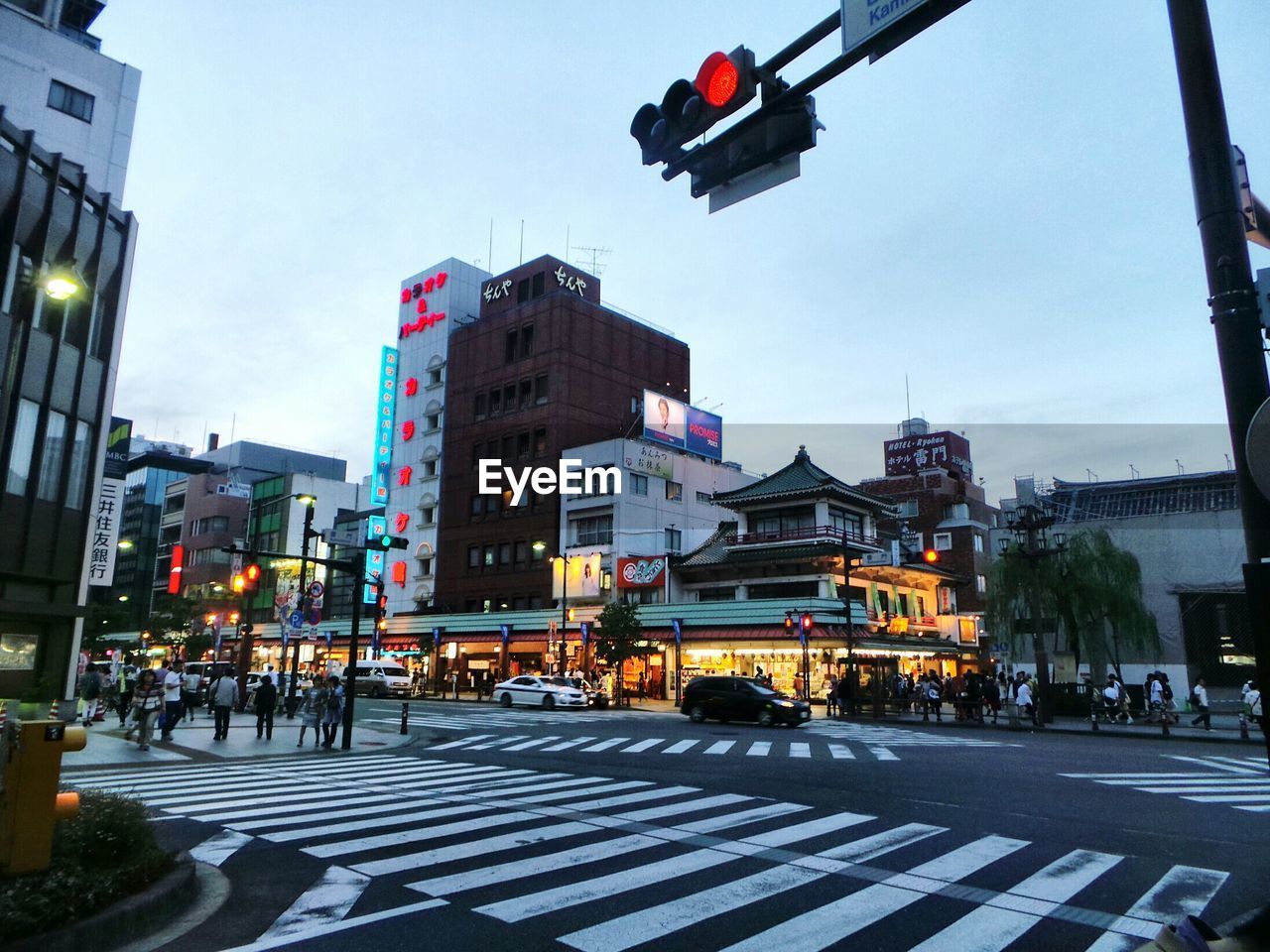 Stoplight over zebra crossing in city during sunset