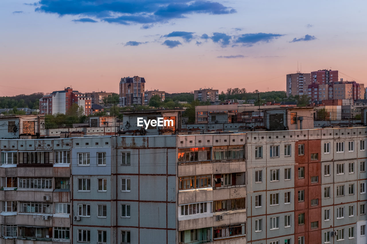 Windows, roofs and facade of an mass apartment buildings in russia at evening