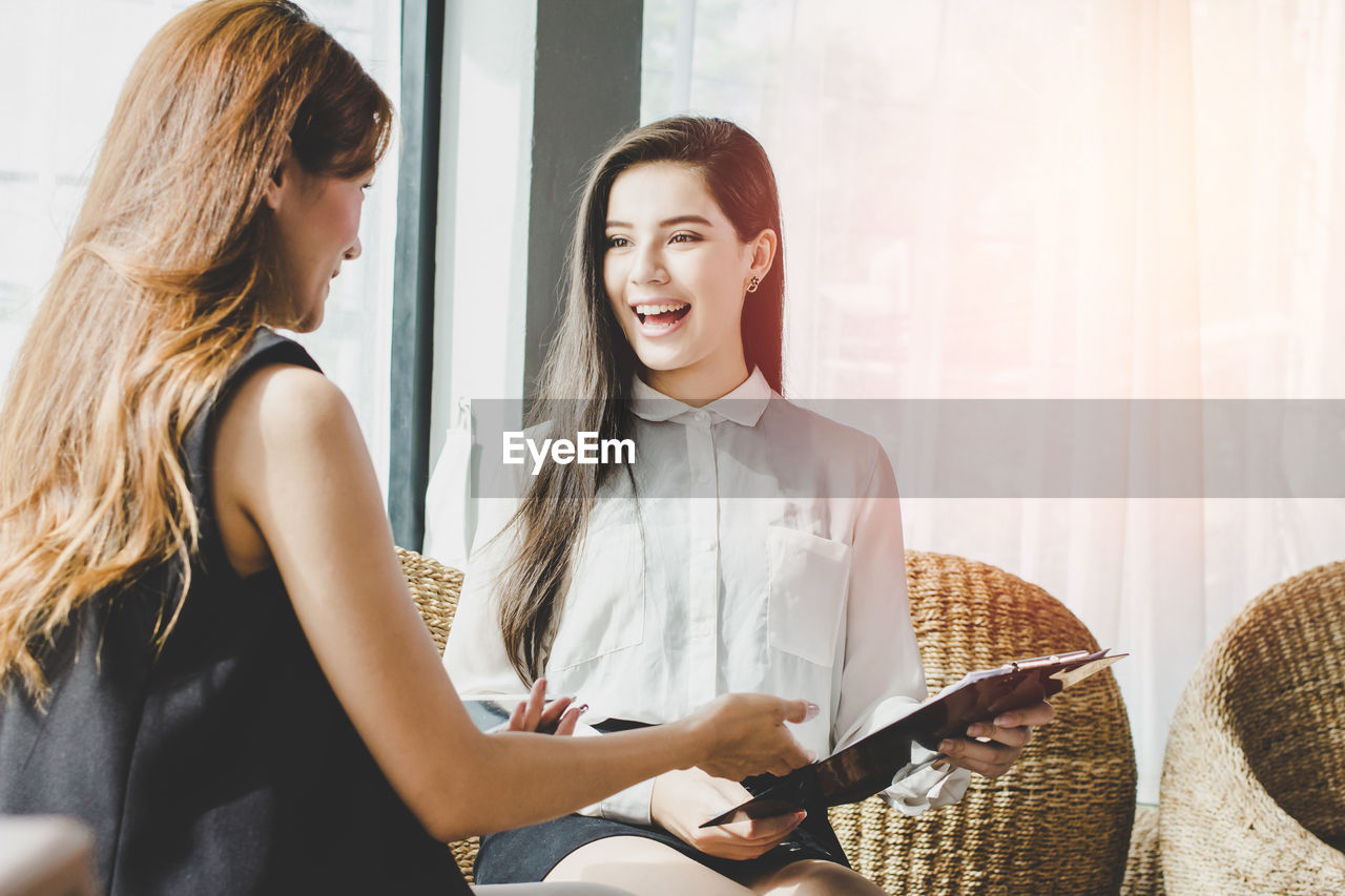 Businesswomen discussing while sitting in office