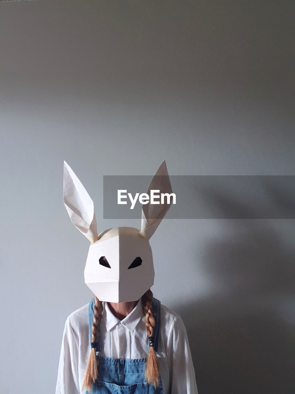 Woman wearing paper rabbit mask with space for text