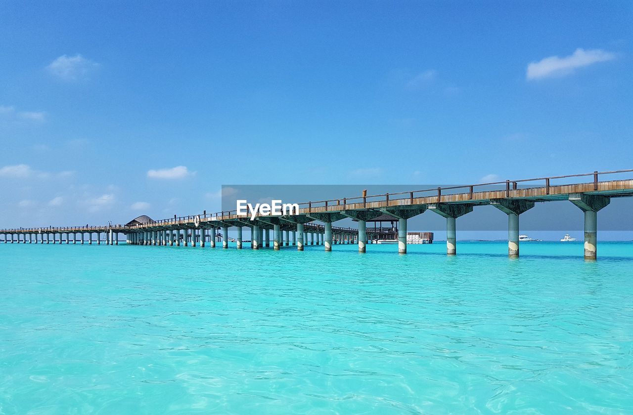 Bridge over sea against blue sky