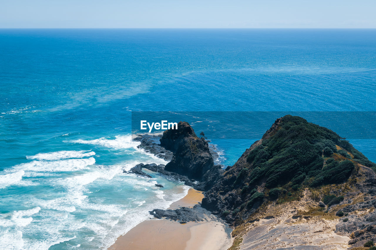 Scenic view of black cliffs against sea against sky