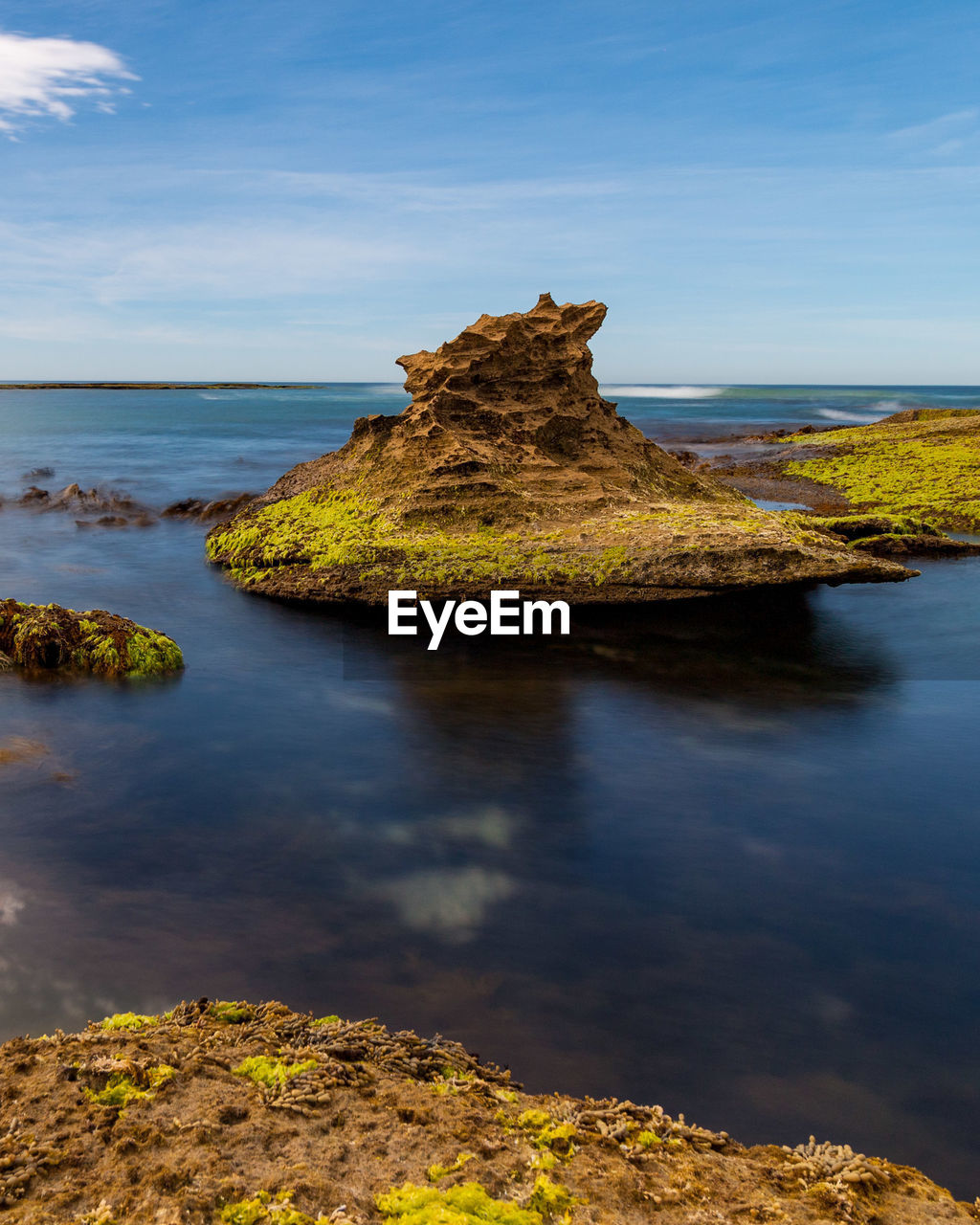 Rock formation on sea shore against sky