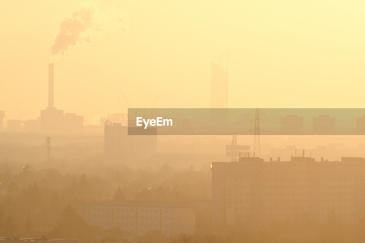 haze, fog, building exterior, architecture, pollution, built structure, city, air pollution, sky, morning, smog, dawn, mist, environmental issues, cityscape, nature, skyline, environment, smoke, sunrise, industry, building, horizon, landscape, no people, factory, smoke stack, silhouette, urban skyline, sun, outdoors, dust, sunlight, city life, skyscraper, office building exterior, residential district, twilight