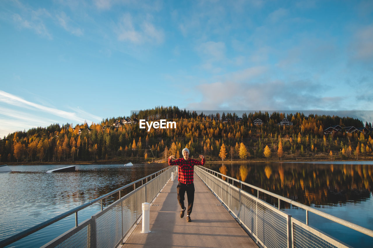 Autumn sunset at lake syvajarvi, in hyrynsalmi, finland. a young man in a plaid red and black shirt