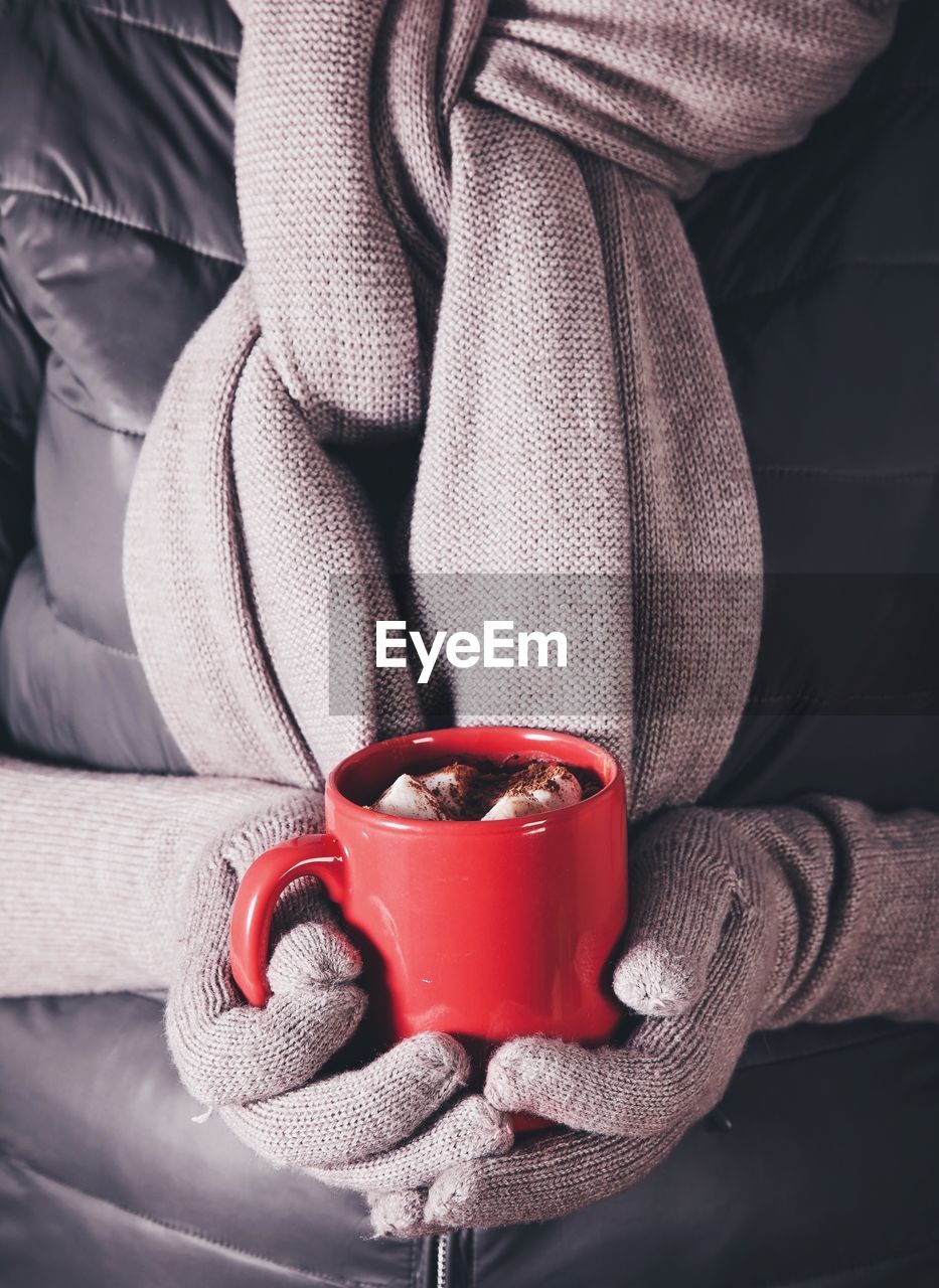 Close-up of hand holding red mug