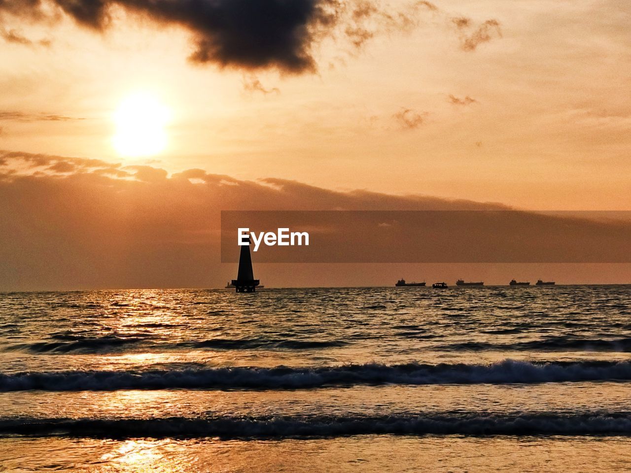 Silhouette sailboat in sea against sky during sunset