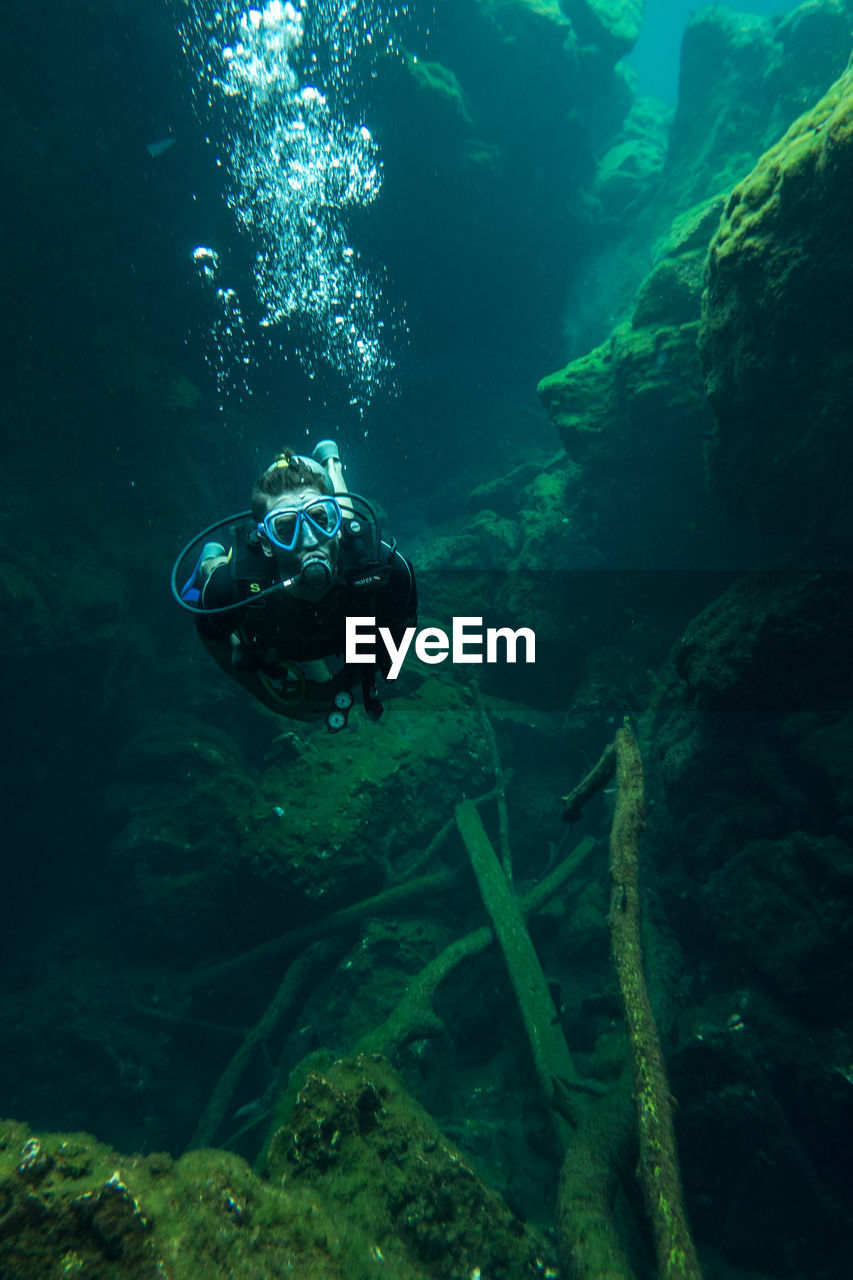 Young man scuba diving undersea