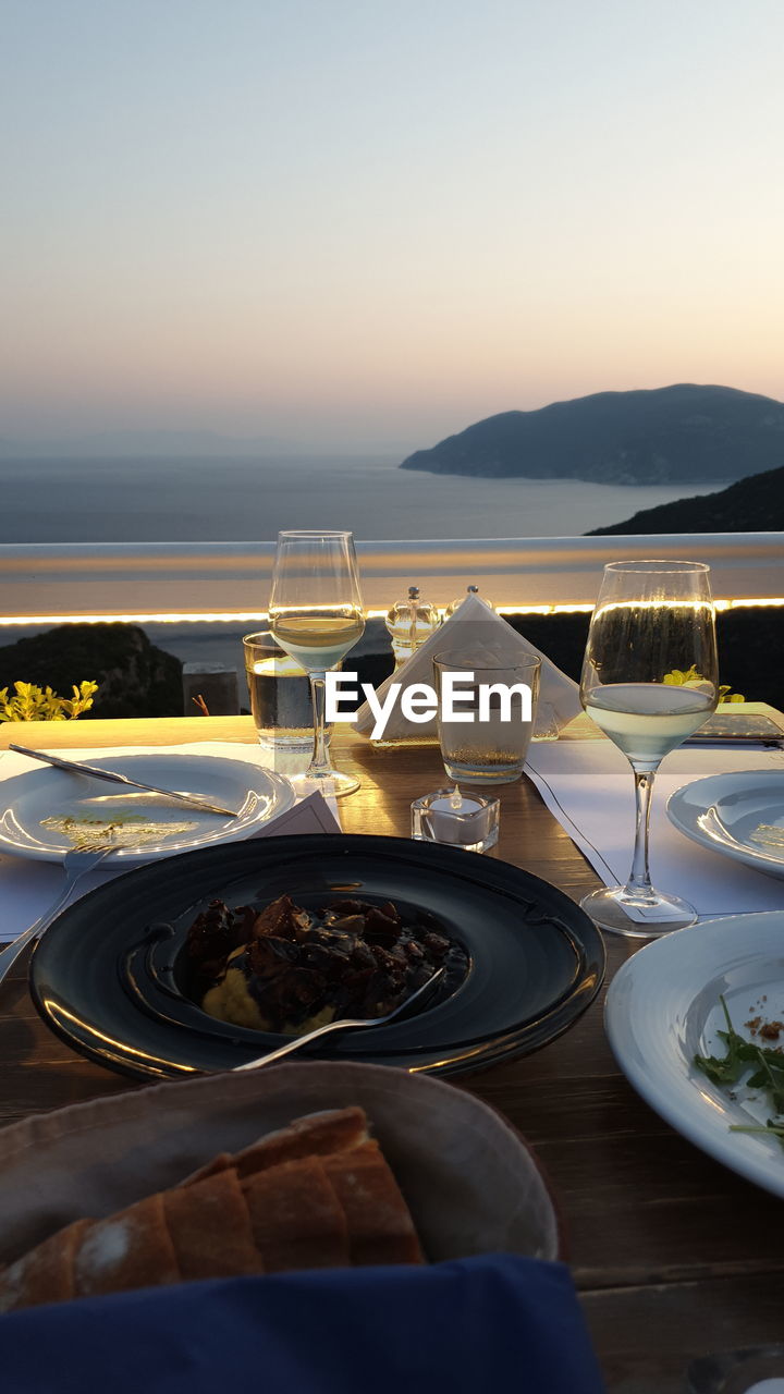 HIGH ANGLE VIEW OF MEAL ON TABLE AT SUNSET