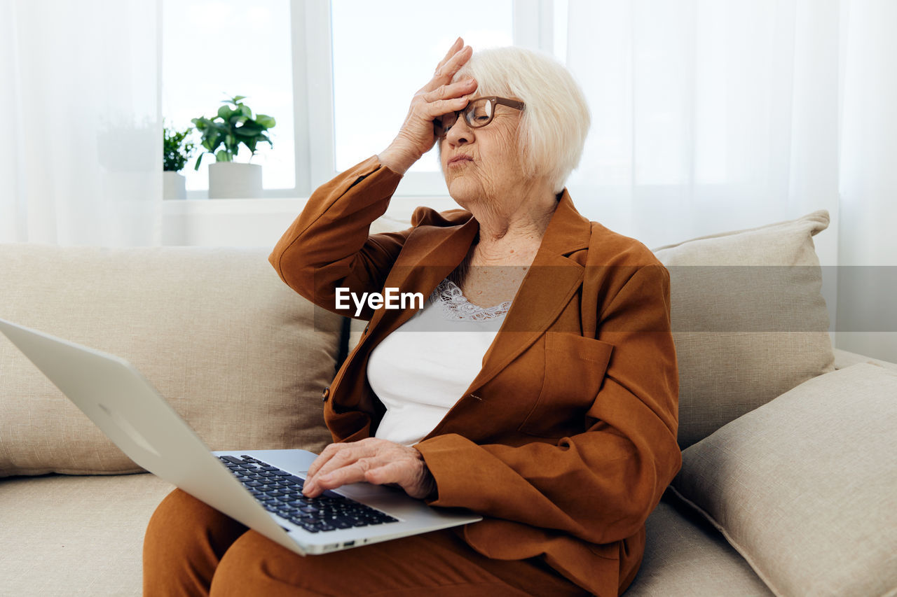 young woman using laptop while sitting at home