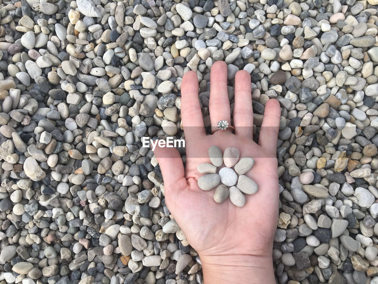 Cropped hand holding pebbles