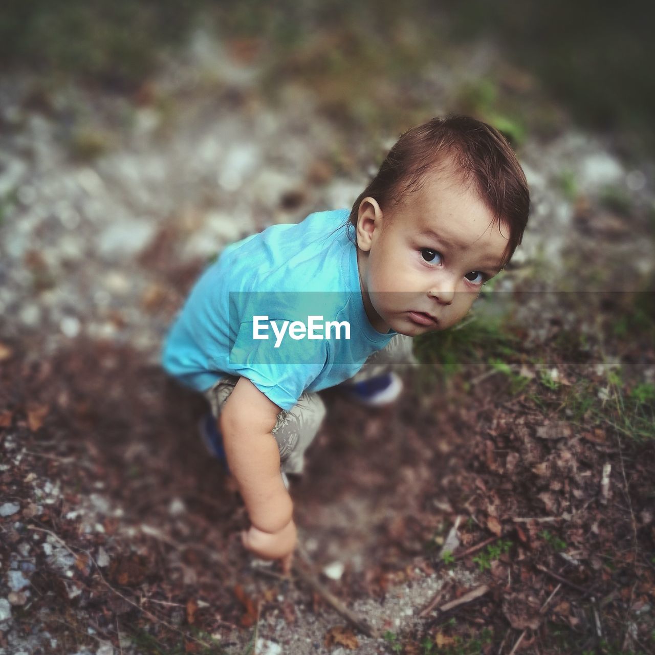 High angle portrait of cute baby boy playing on dirt field