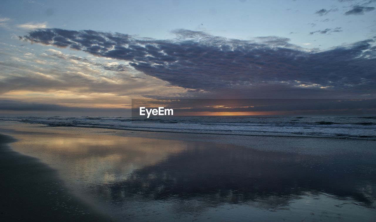 Scenic view of beach against sky during sunset