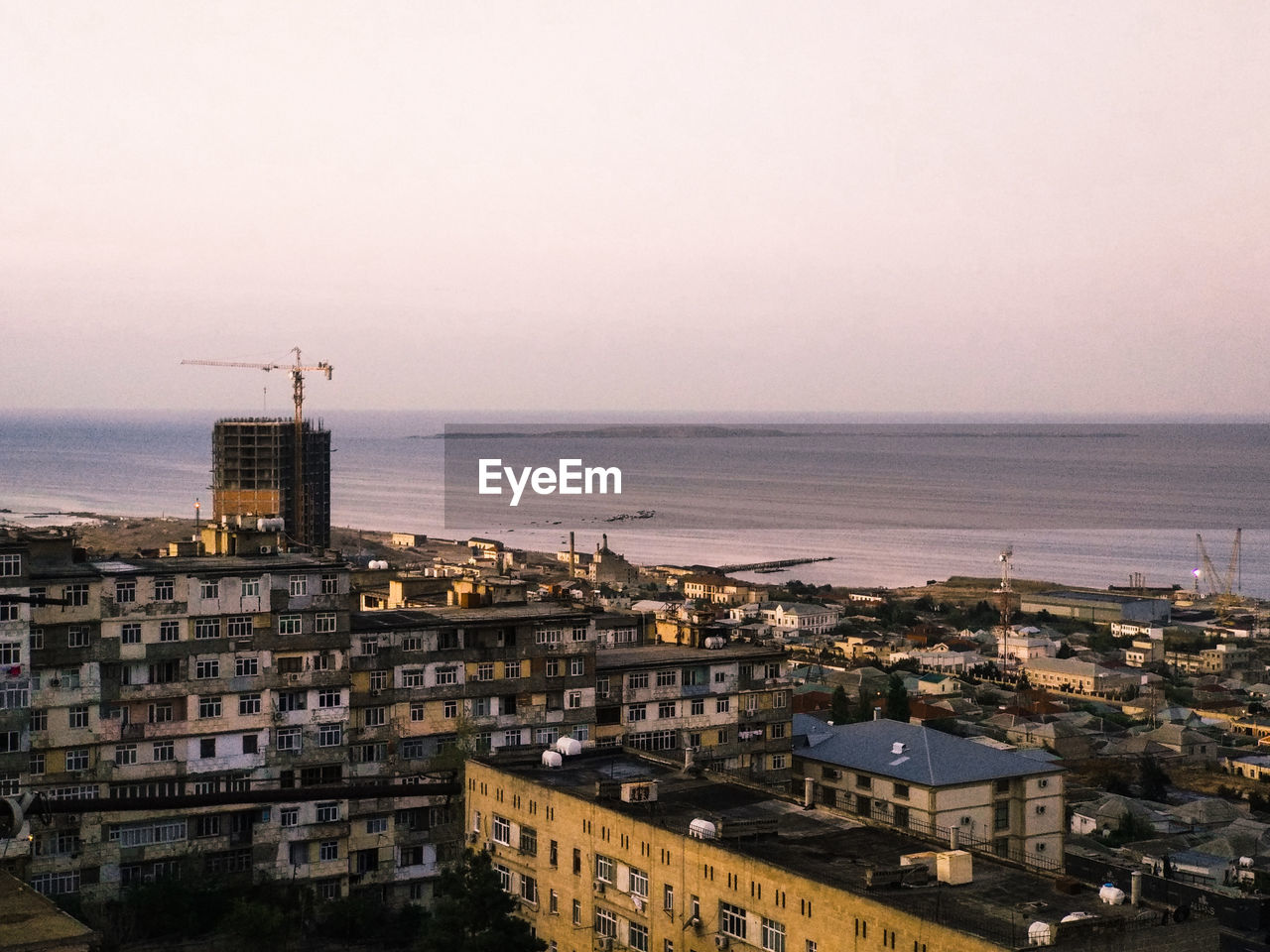 High angle view of townscape by sea against clear sky