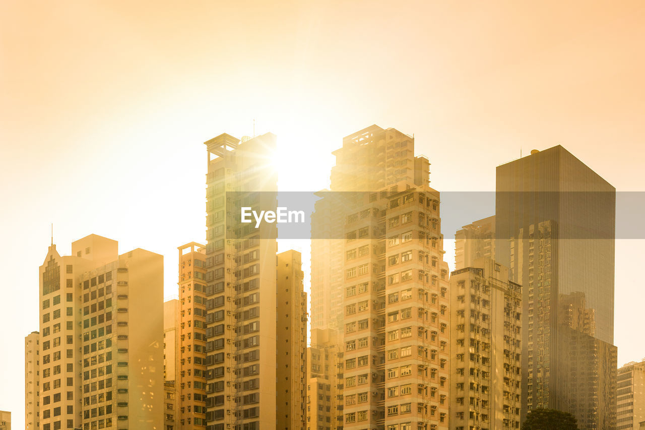 Sunset behind skyline of apartment buildings in the neighborhood of chung wan, hong kong, china.