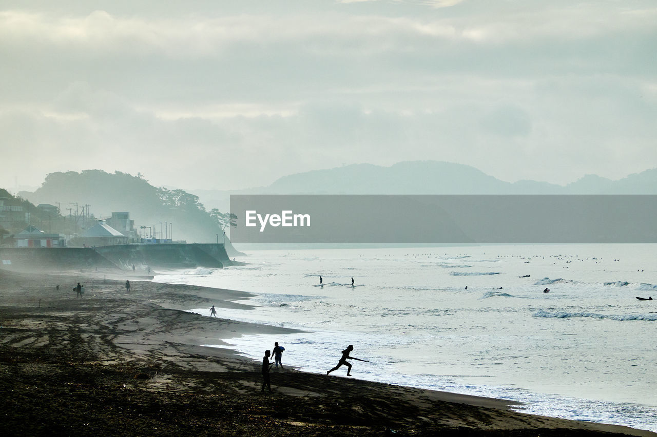 People on beach against sky