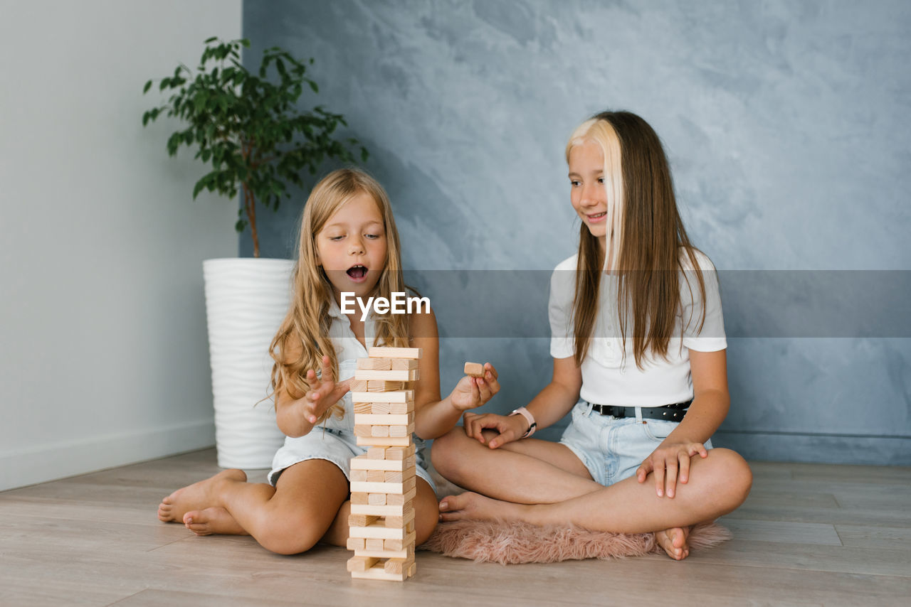 Caucasian sisters, the family spends time together on vacation in the living room of the house